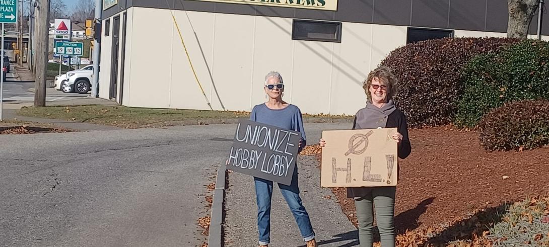 Protesters with signs that say Unionize Hobby Lobby and No HL
