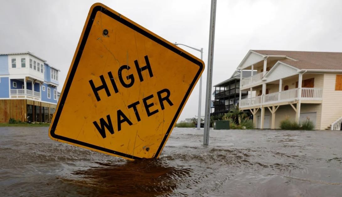 Flooded street with sign that says "high water"